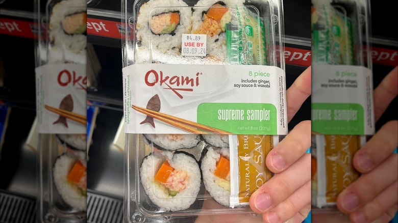 Hand holding package of 7-Eleven's Okami sushi