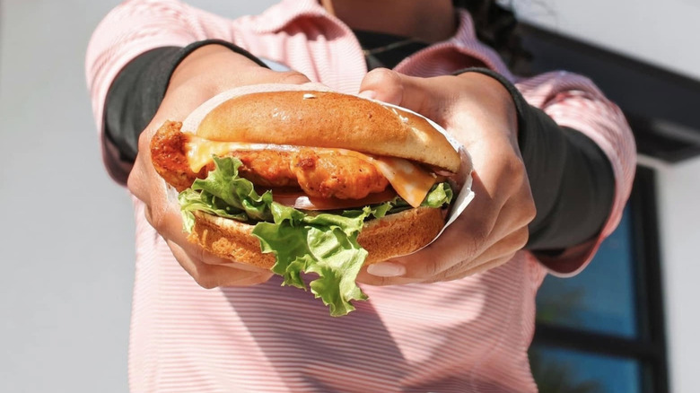 Hands holding Chick-fil-A chicken sandwich