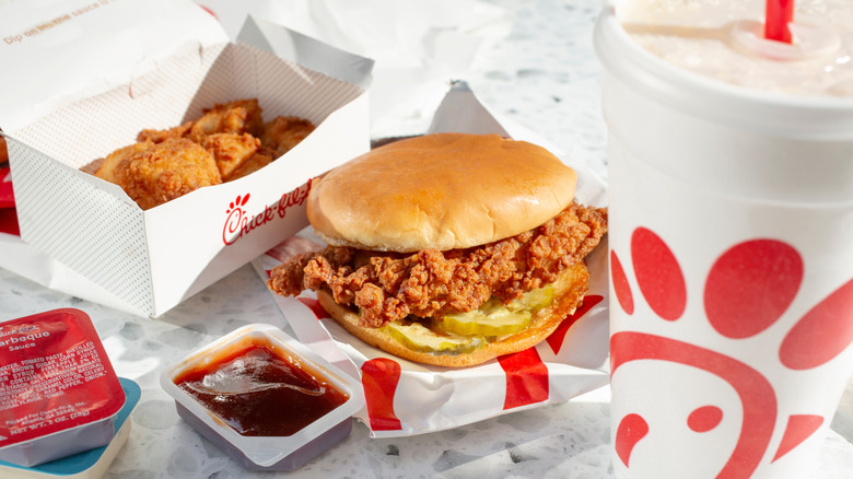 A Chick-fil-A sandwich with nuggets, sauce, and drink