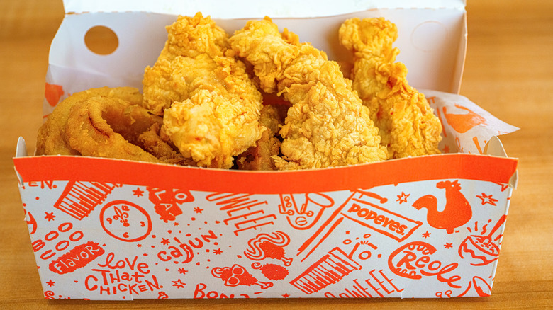 A box of Popeyes chicken tenders and onion rings