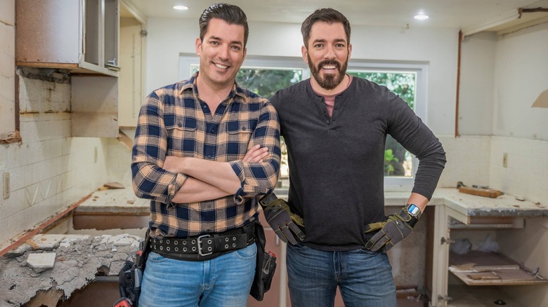 The Property Brothers, Jonathan and Drew Scott, stand in a kitchen they're renovating