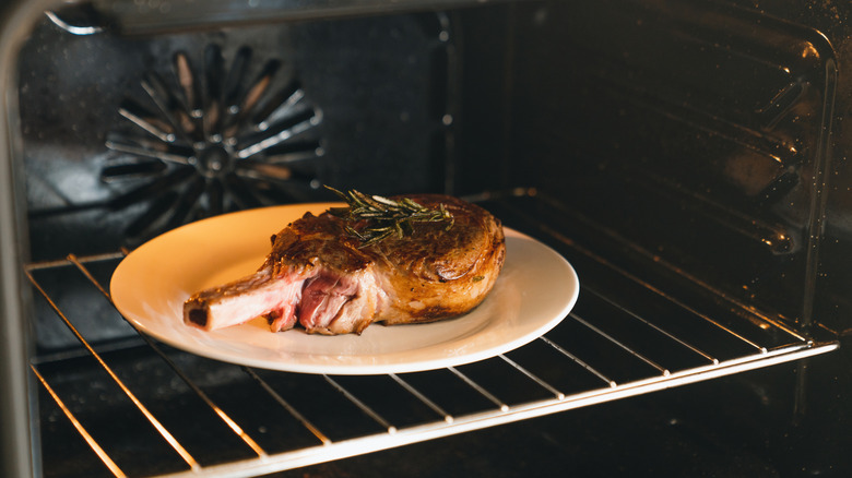 Beef with a bone on a plate under the broiler