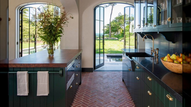 A spacious kitchen with herringbone brick flooring