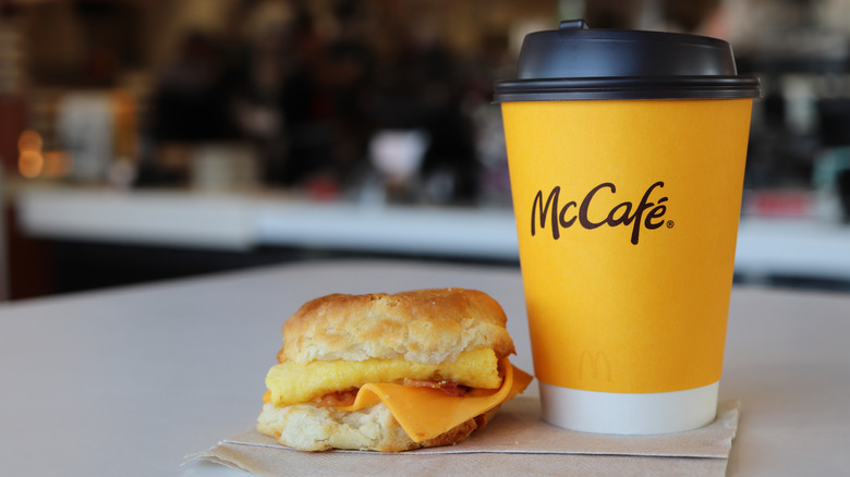 A cup of coffee from McDonald's and a breakfast biscuit with cheese and egg