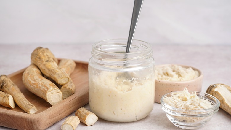 Horseradish sauce in jar with whole root