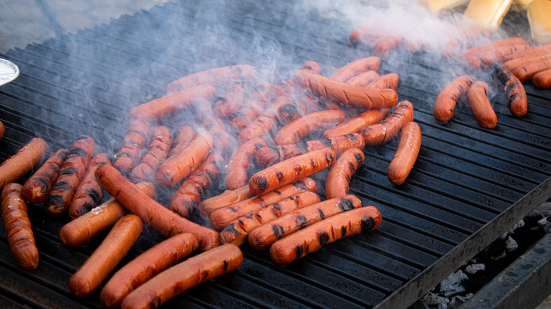 Frankfurters being cooked on a grill