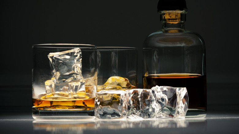 Brown liquor over ice in glasses
