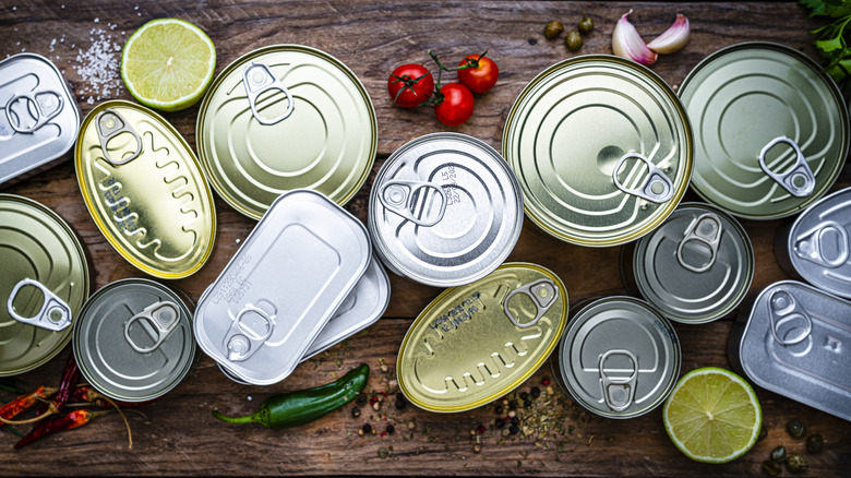 Selection of various canned foods with limes and tomatoes