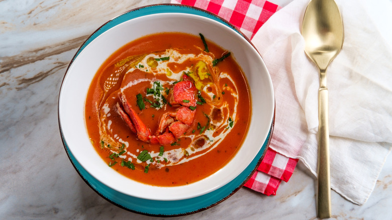 A bowl of lobster bisque, garnished with a lobster tail