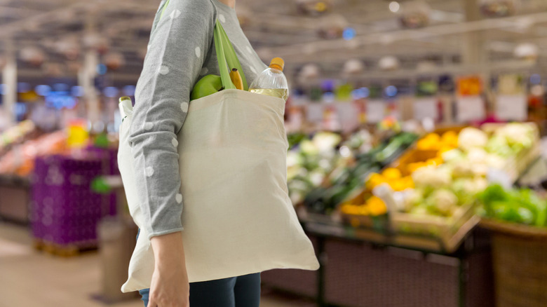 women holding reusable grocery bag in supermarket