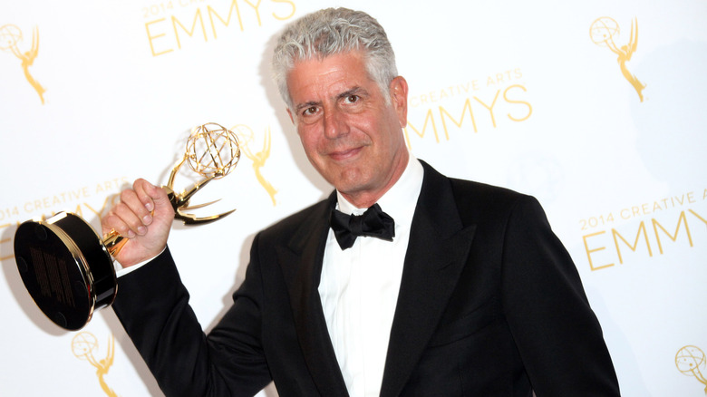Anthony Bourdain holding an Emmy award