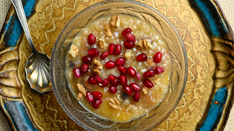 bowl of ashure pudding topped with pomegranate and walnut