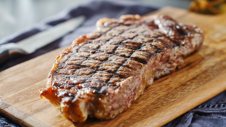Cooked steak resting on cutting board before serving