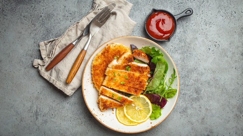breaded chicken cutlet over salad