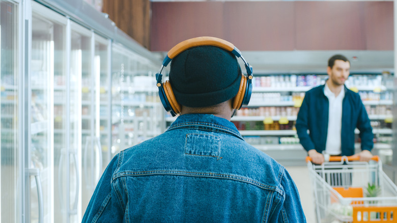 A person wears headphones at the grocery store