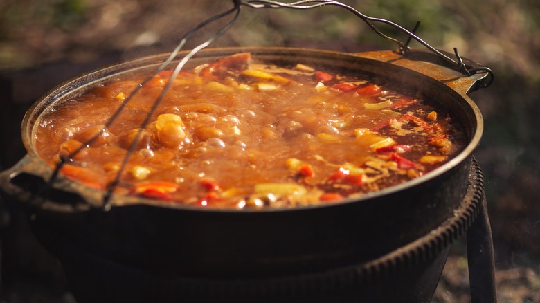 Alabama camp stew simmering in campfire pot