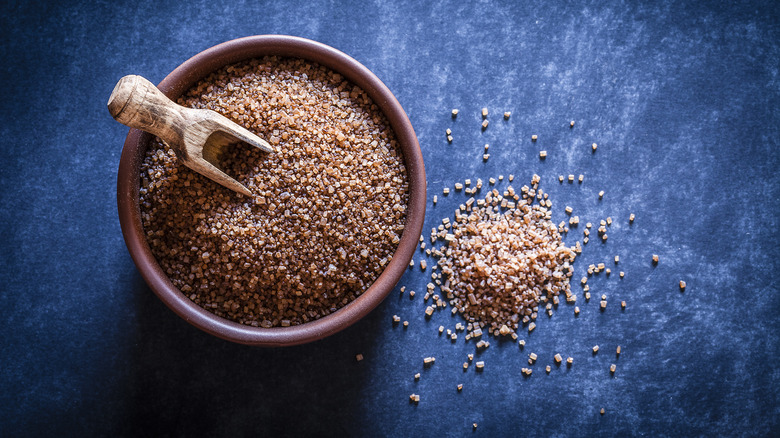 Unrefined sugar against blue backdrop