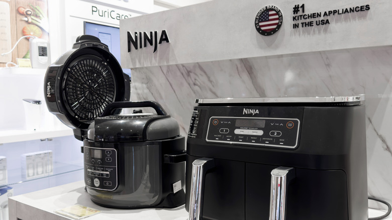 A variety of Ninja appliances sit on a display cabinet in a retail store