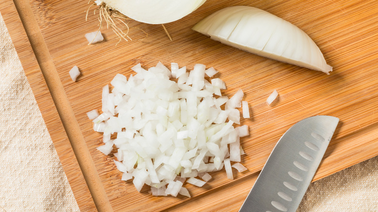 Chopped onions on a wooden cutting board