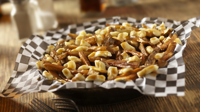 Poutine in a bowl with forks.
