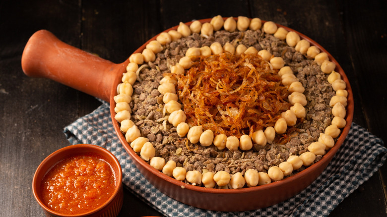 plated koshary garnished with chickpeas and crispy onions