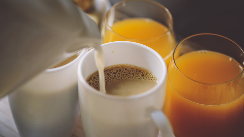 A cup of coffee with two glasses of orange juice.