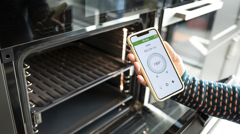 hand operating smart oven with phone