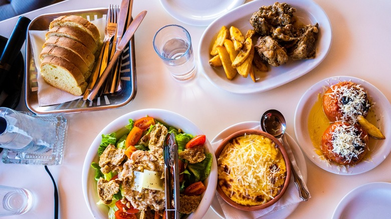 Table with sliced bread and assorted greek dishes