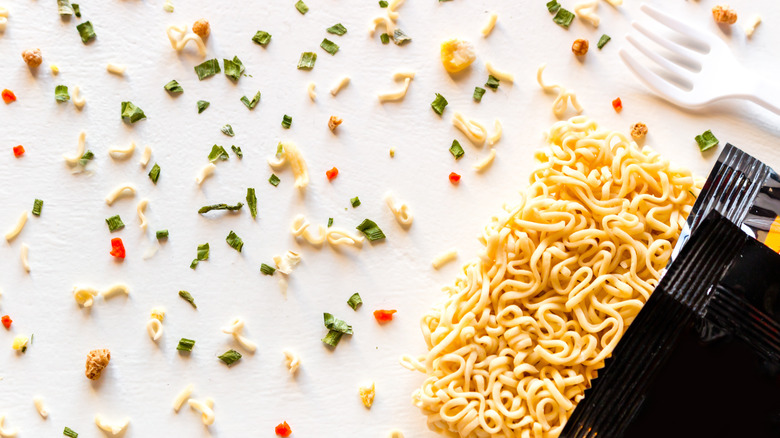 Dried ramen noodles and seasoning with fork