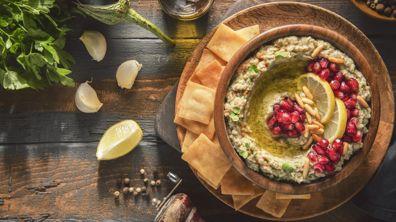 baba ganoush topped with pomegrante seeds, pine nuts, lemons, and olive oil