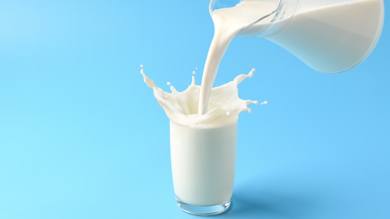 pitcher pouring milk in glass