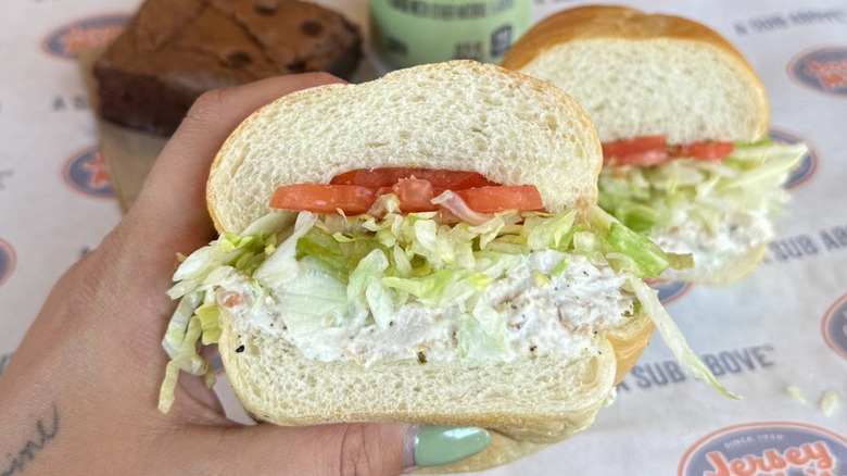 A hand holds out a Jersey Mike's sub