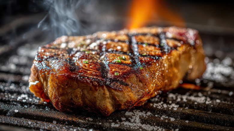 A steak cooking on the grill
