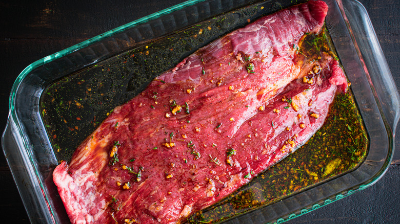 Steak marinating in pan