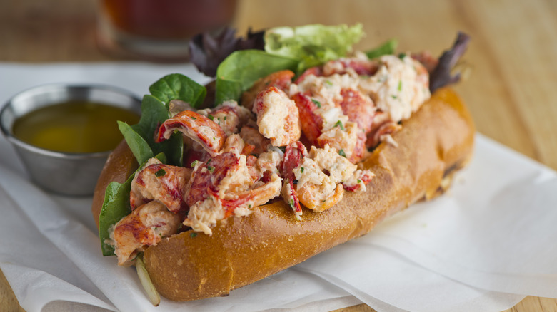 A Maine lobster roll with a side of butter.