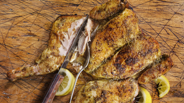 carving into a rotisserie chicken