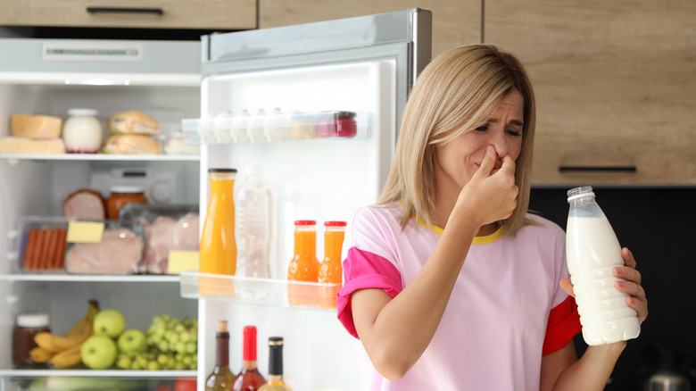 Woman sniffing bad milk