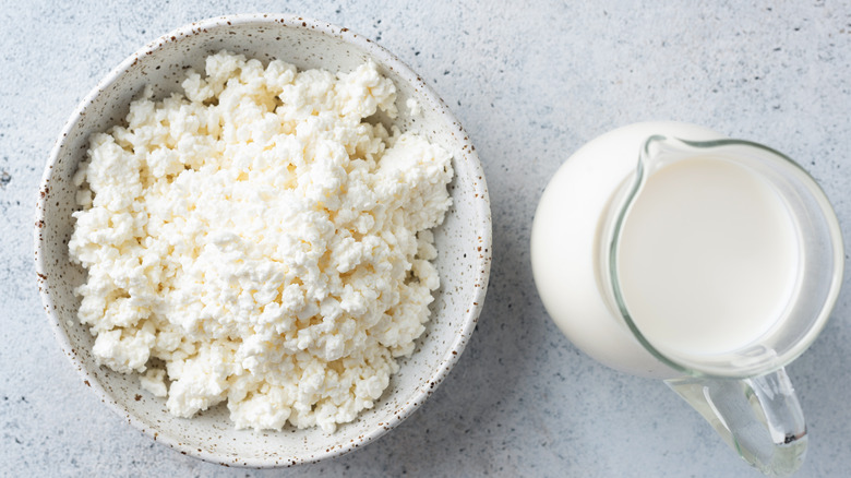 white bowl filled with cottage cheese next to milk