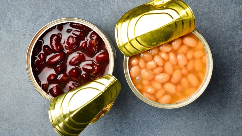 Two open cans of beans on gray surface