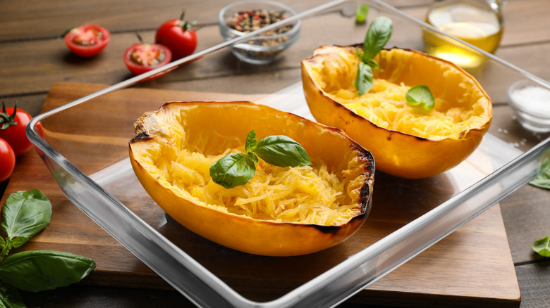 Roasted spaghetti squash halves in glass baking pan