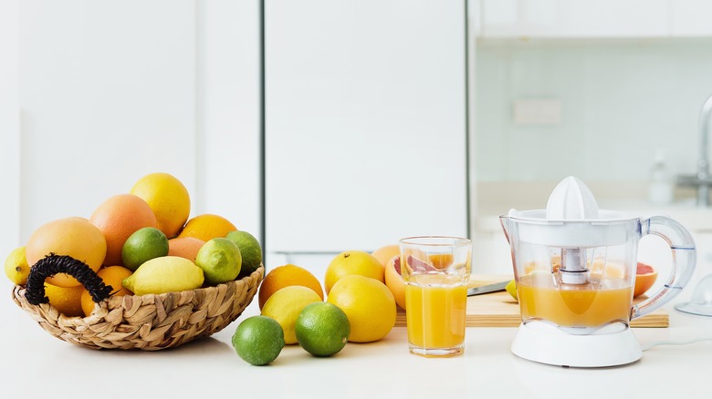 Citrus with glass of fresh juice and juicer