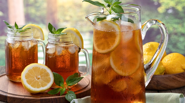 pitcher of iced tea next to mason jar iced tea cups