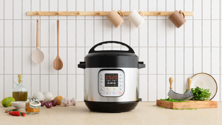 A pressure cooker sits on a clean counter in a bright kitchen