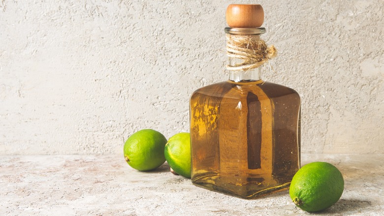 Bottle of tequila with limes
