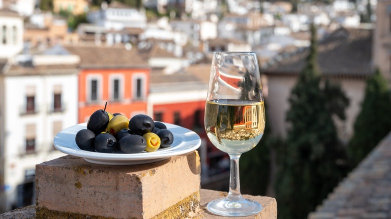 glass of sherry outdoors near tray of olives