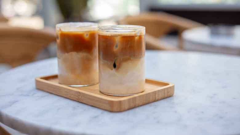 Two iced lattes on marble table