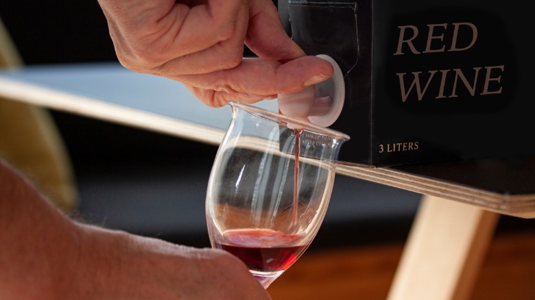 Red wine being poured out of a box tap 