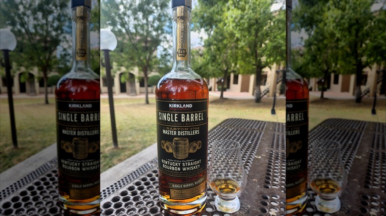 A bottle of Kirkland Single Barrel Bourbon Whiskey next to a whiskey tasting glass.