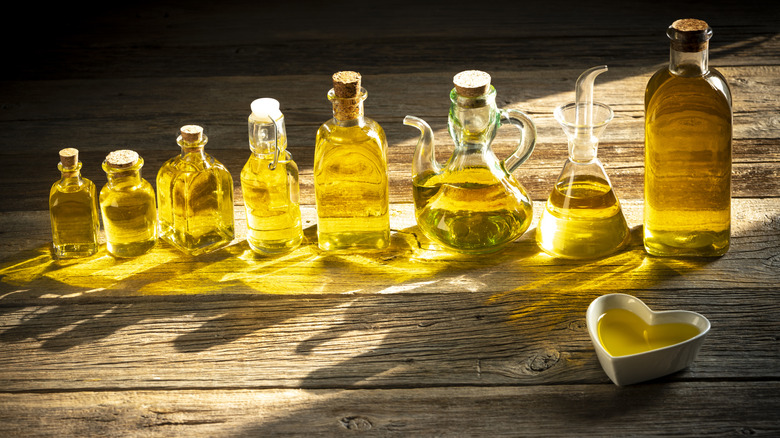 Different bottles of olive oil on a wooden bench