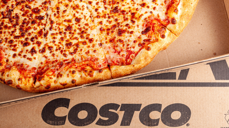 A Costco pizza sits inside its box with the Costco logo